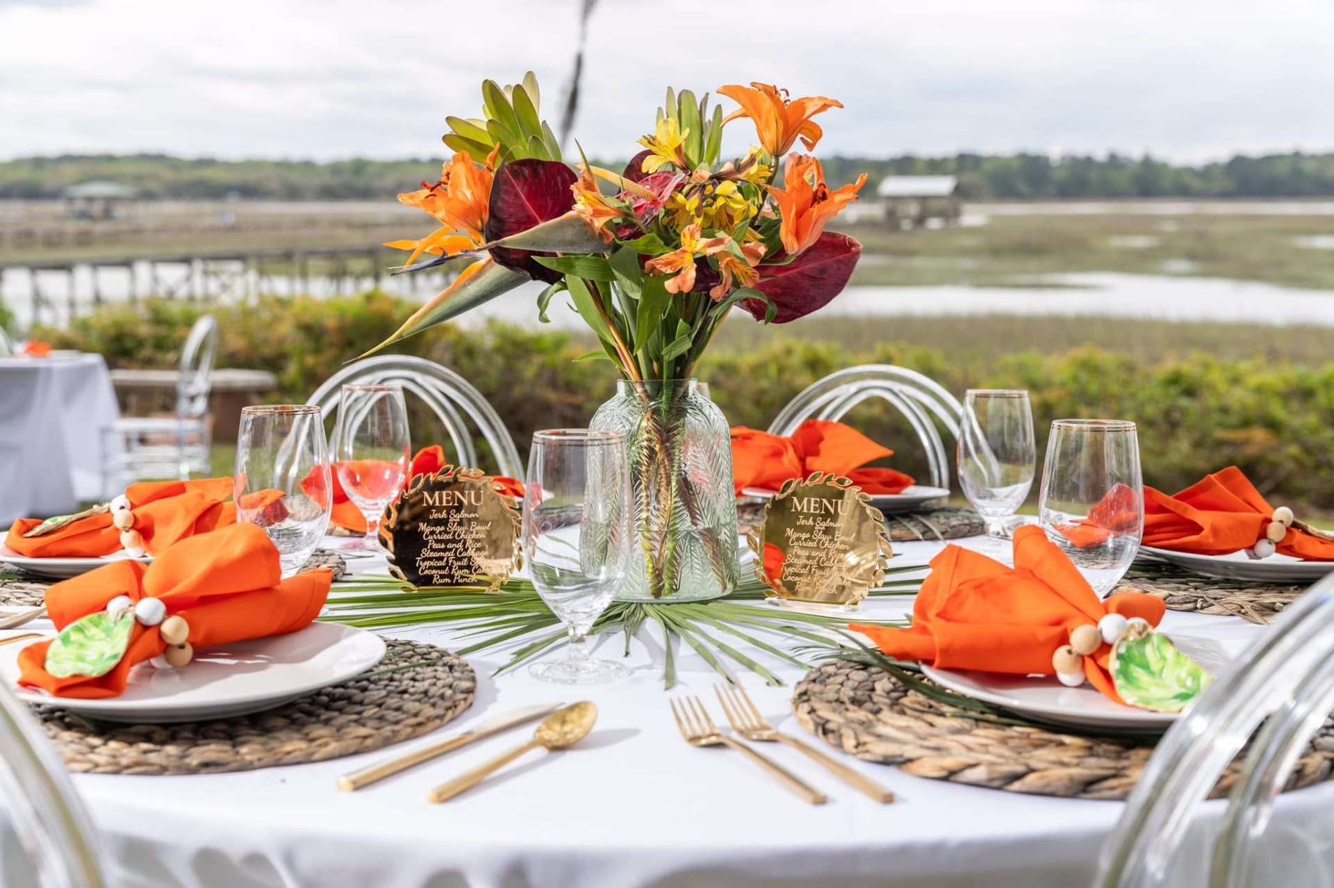 Lowcountry wedding tablescape with tropical florals and gold flatware
