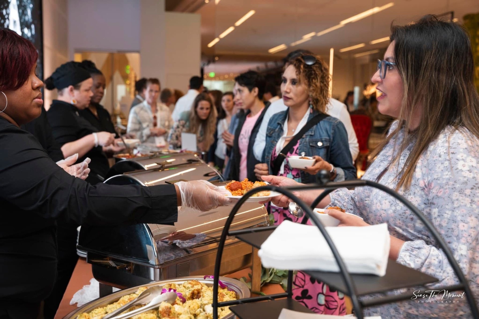 Chef team serving guests down a catered buffet line